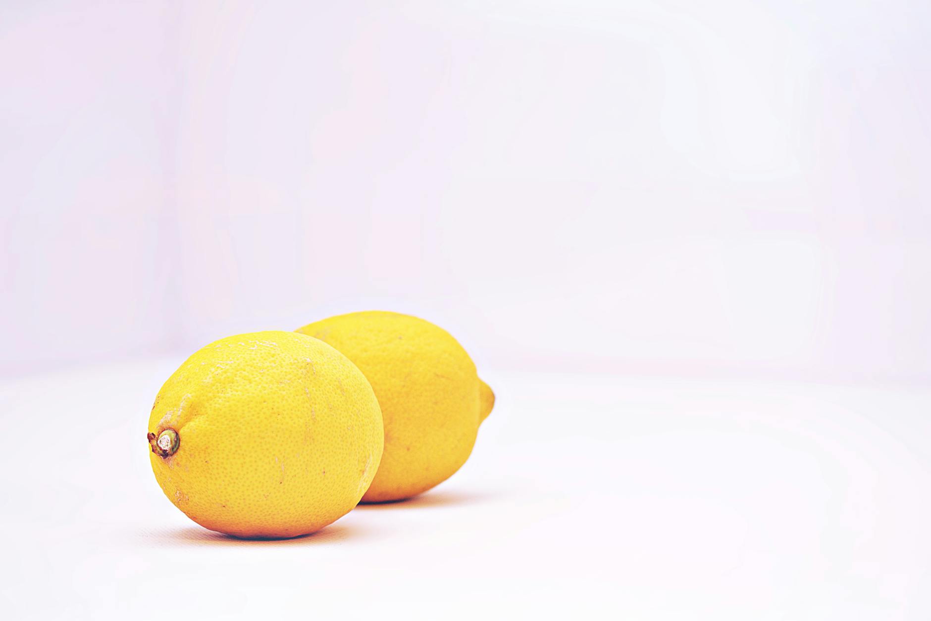 Two bright yellow lemons on a white background, symbolizing the lemon clitoral vibrator