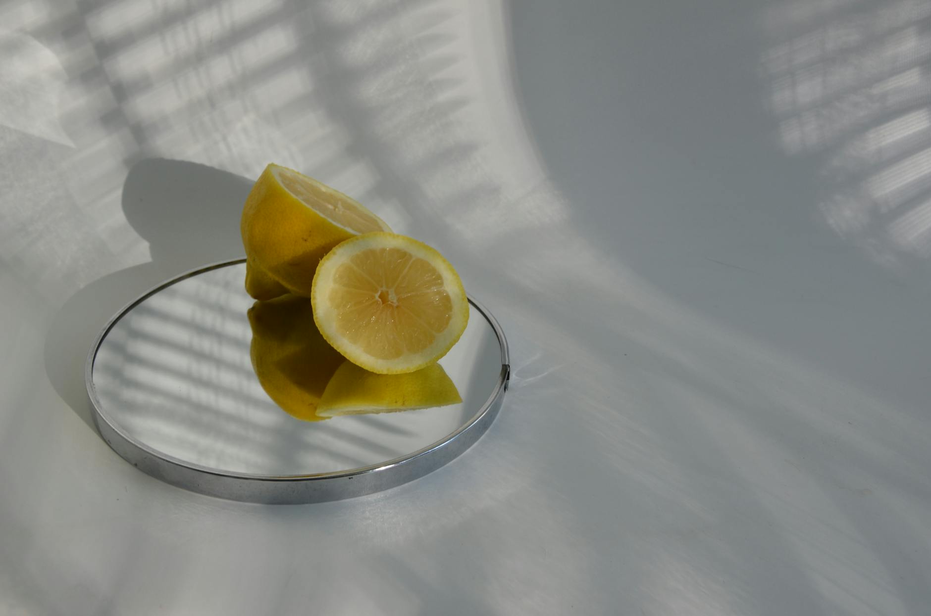 Sliced lemons on a mirror casting shadows, symbolizing clarity and reconnection