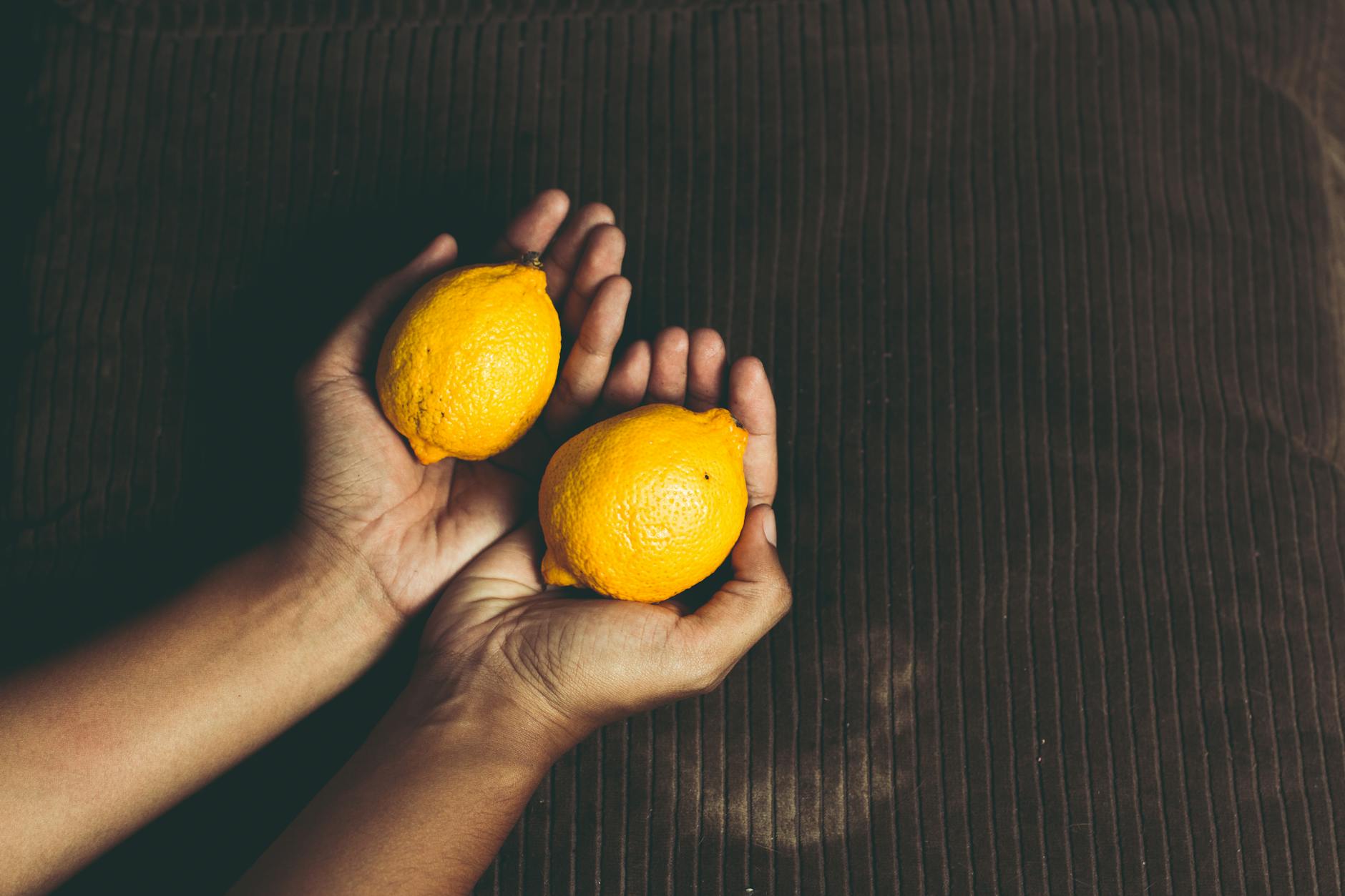Fresh, ripe lemons arranged on a yellow studio background, symbolizing vitality and renewal
