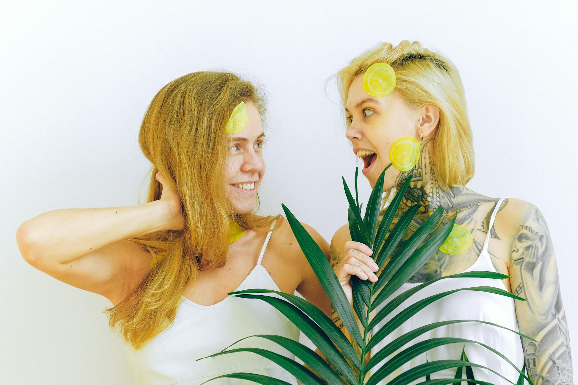 Two women smiling together indoors with fresh lemons, representing joy, connection, and openness between partners