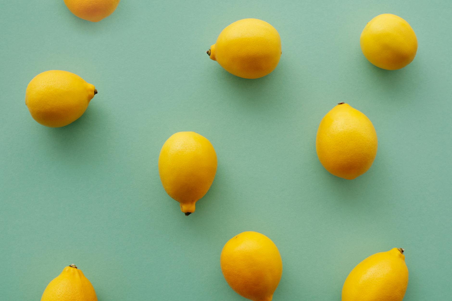 Bright yellow lemons arranged on a pastel background, representing the fresh, pressure-free approach to pleasure